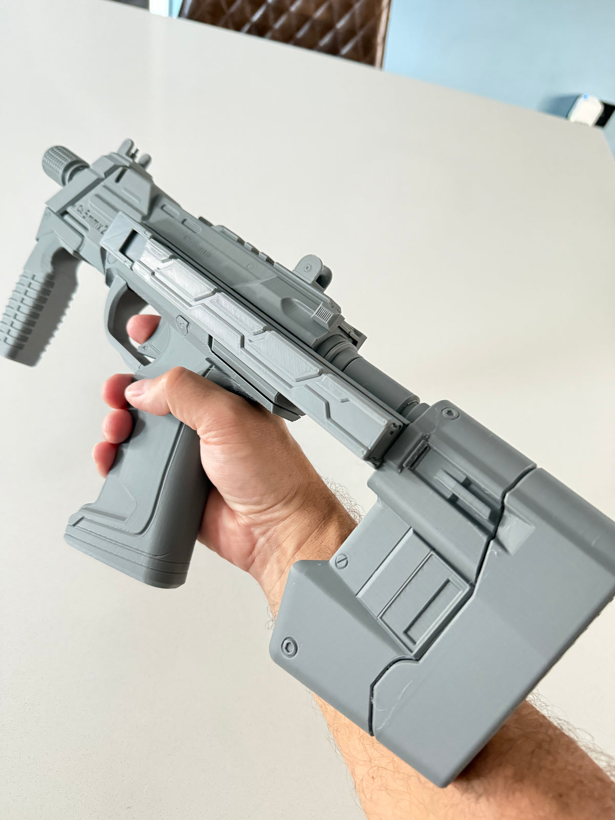 Assembled M7 Caseless SMG prop held in hand, right side, stock extended