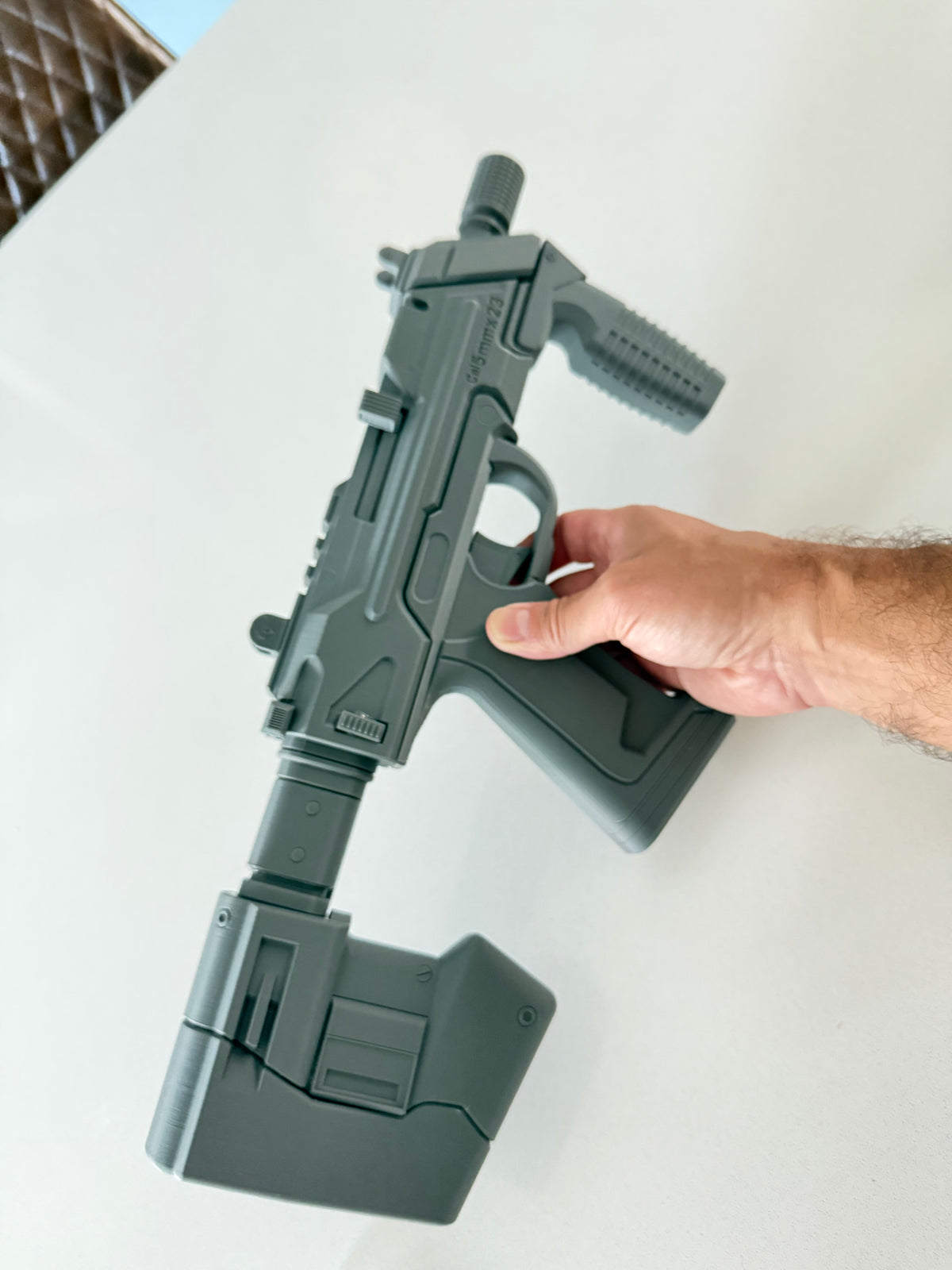 Assembled M7 Caseless SMG prop held in hand, left side, full length with extended stock