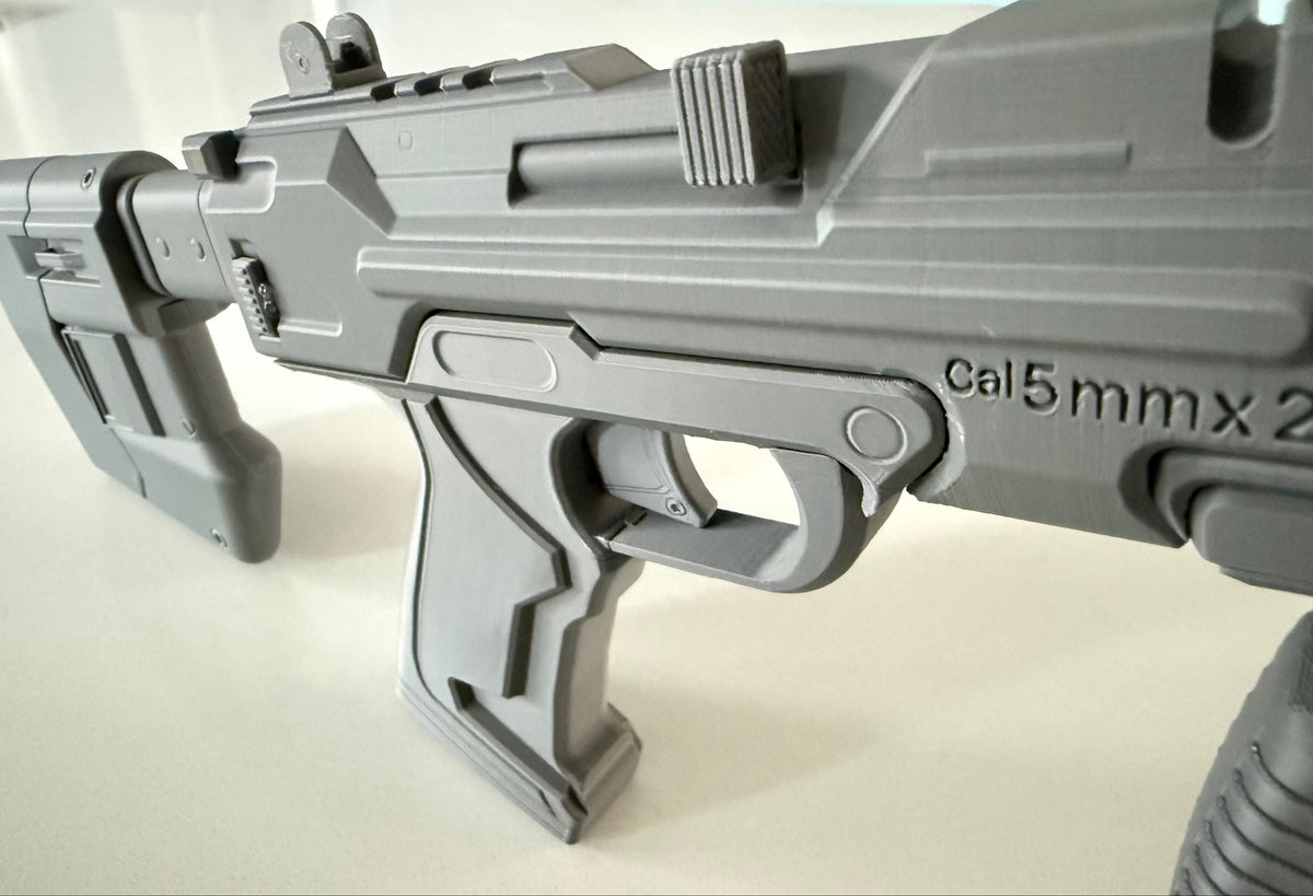 Close-up of the M7 Caseless SMG prop's front sight, top rail and trigger guard detail
