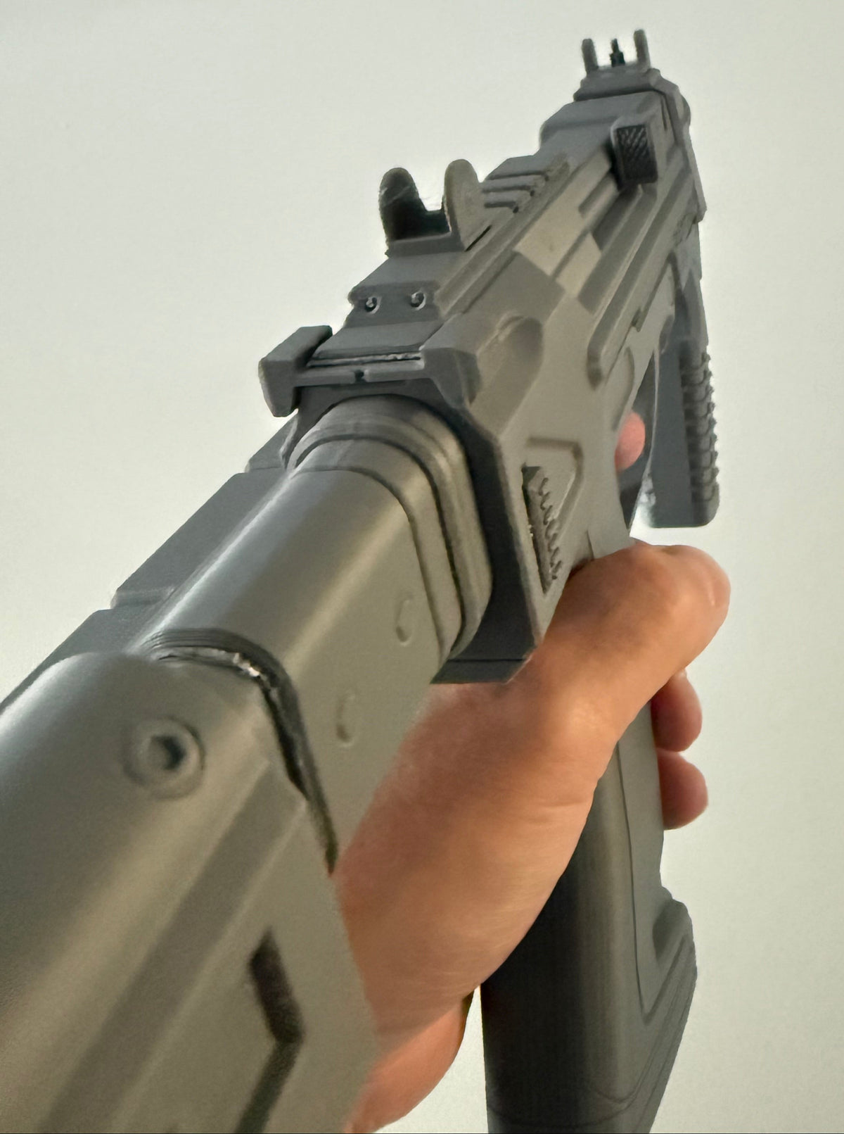 M7 Caseless SMG prop held up close showing the front sight and Cal 5mmx23 engraving