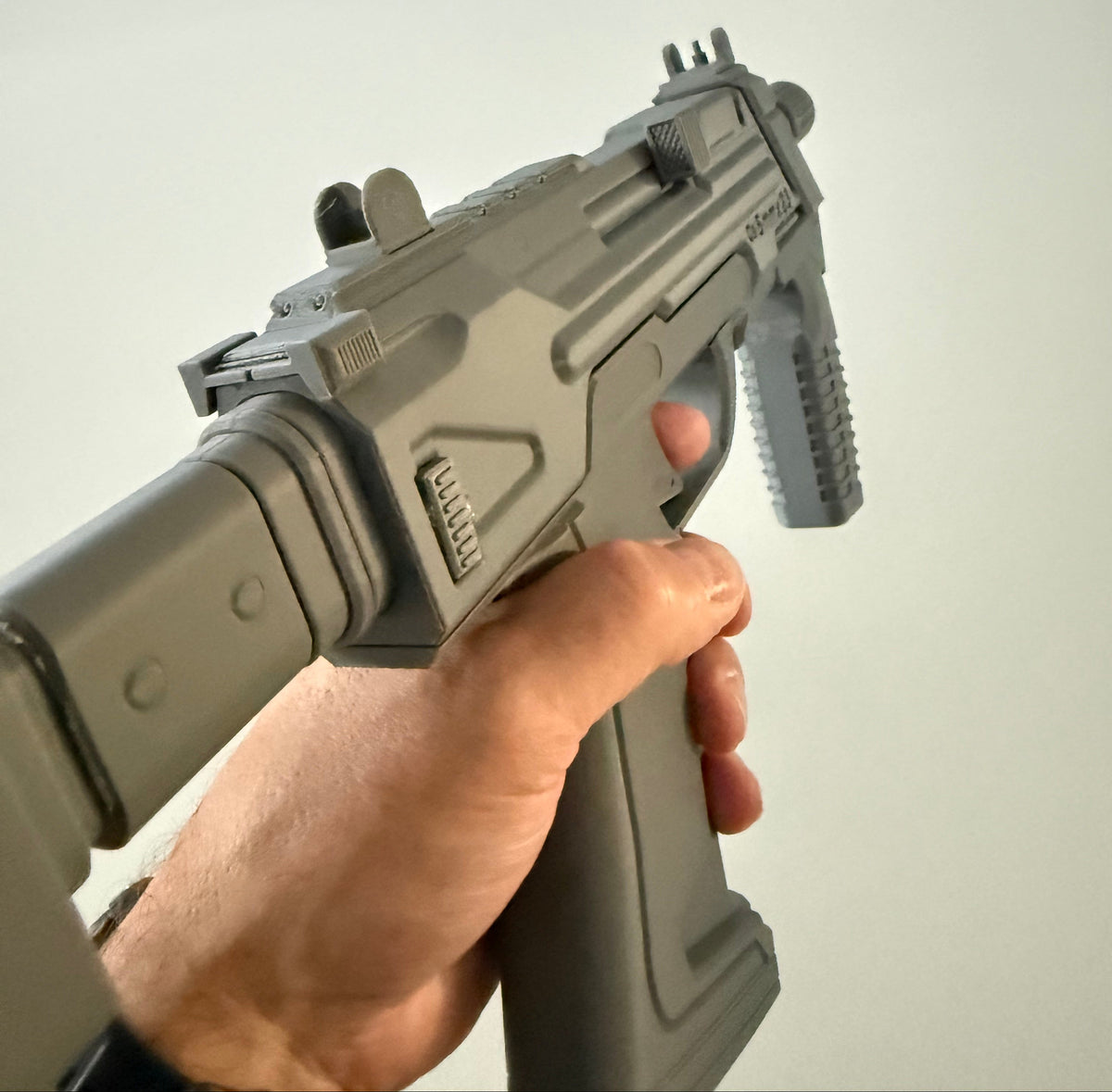 M7 Caseless SMG prop held in hand, close-up of front sight and top rail from a different angle