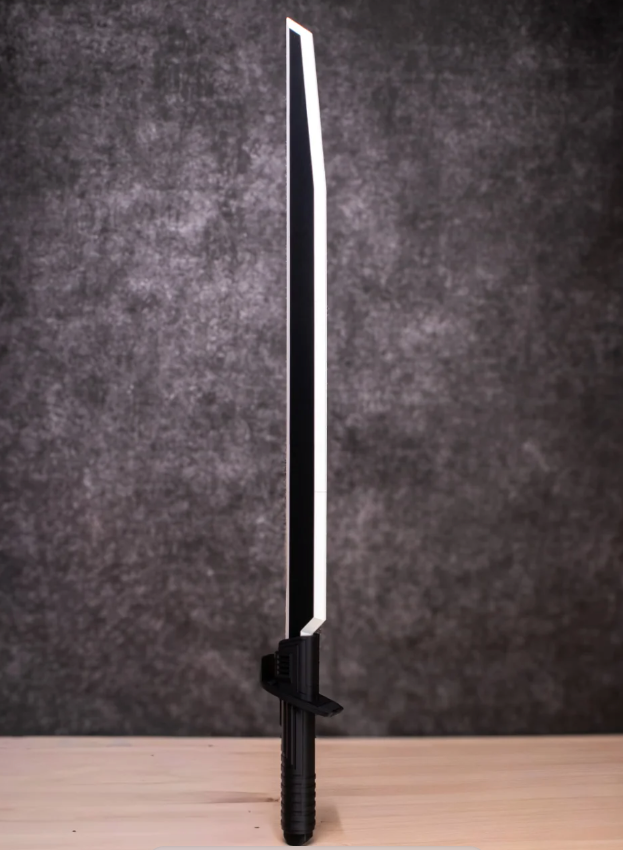 Black sword with a reflective blade on a dark gray background
