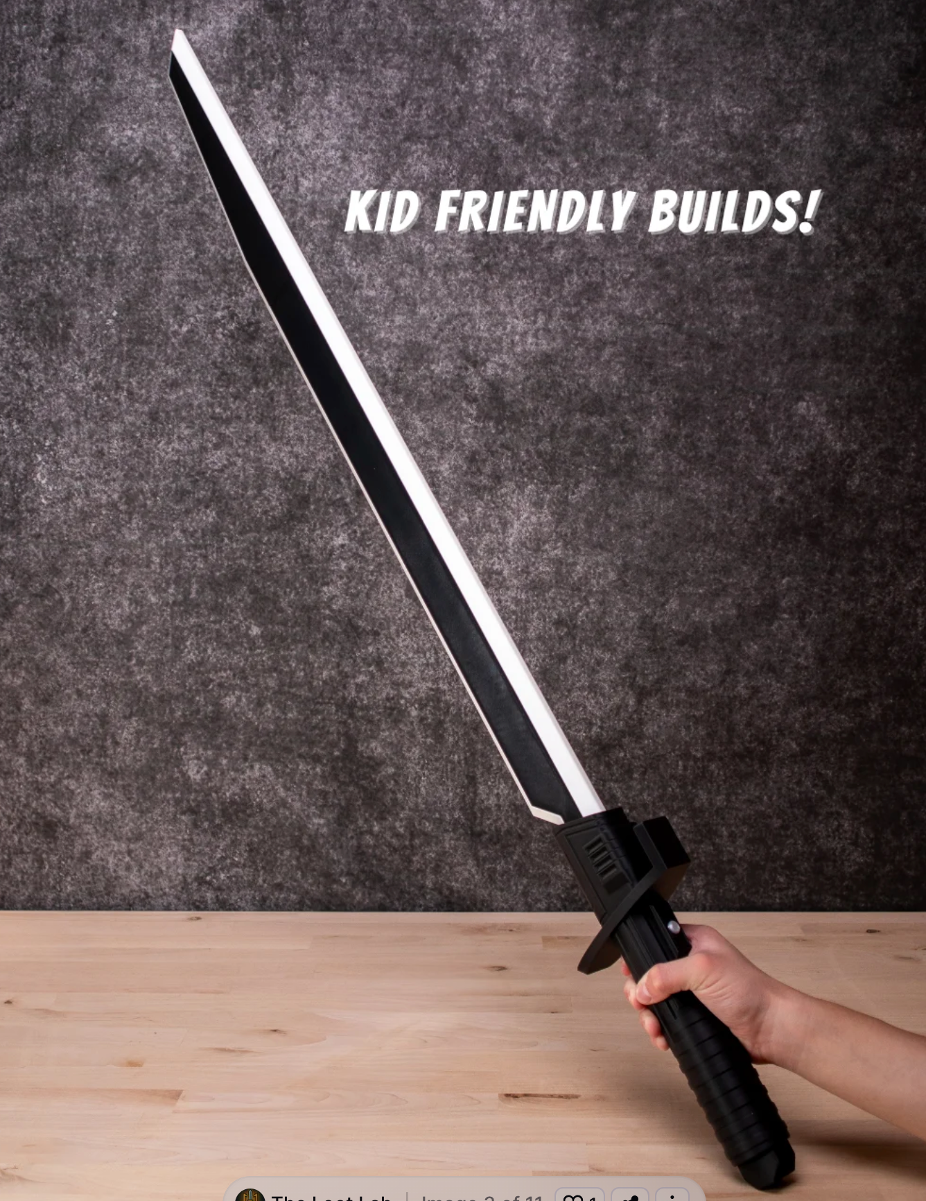 Light saber held by a hand on a wooden surface with a dark gray background and text 'KID FRIENDLY BUILDS!'.