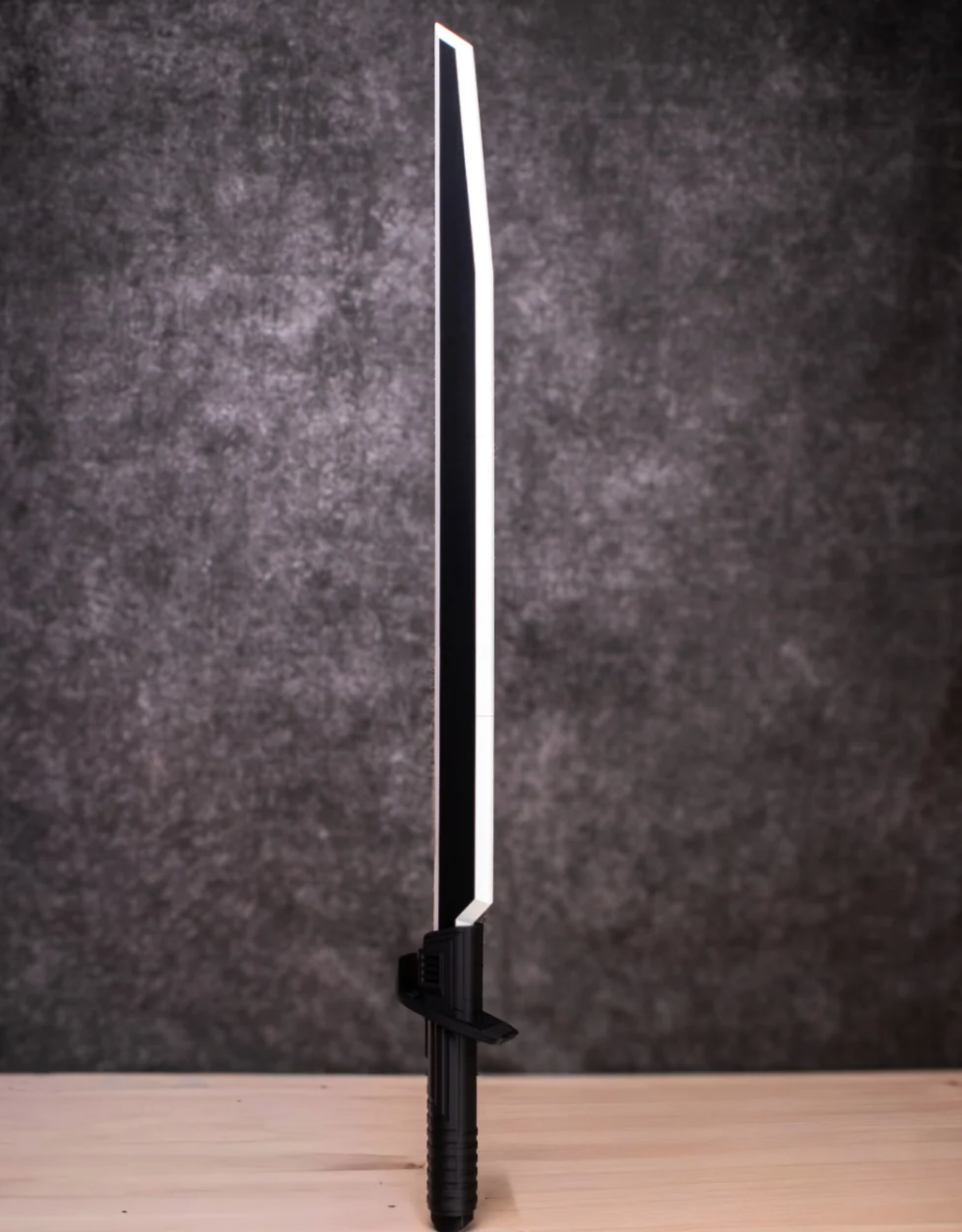 Black sword with a white blade on a dark gray background