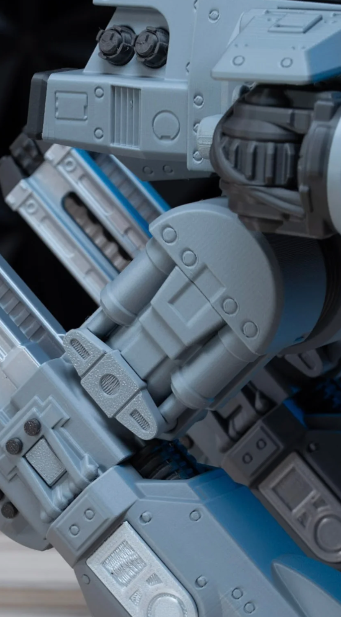 Close-up of the ED-209 kit's leg and cannon joint, showing the printed panel lines and rivet detail