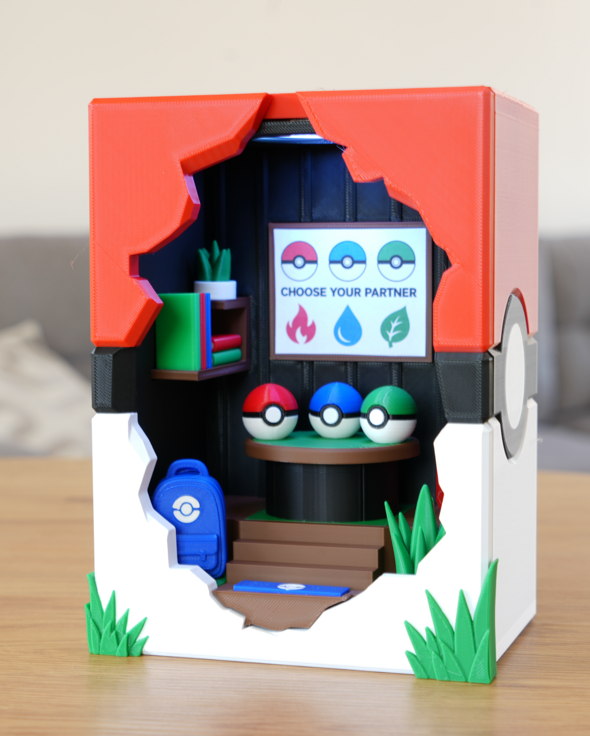 Choose Your Starter Broken Brick LED Lamp, front view of the Pokéball-shaped diorama showing the Choose Your Partner sign, bookshelf, plant and backpack